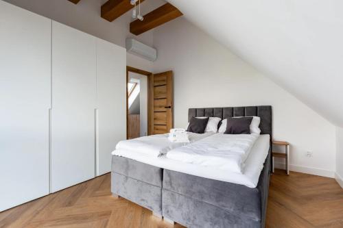 a bedroom with a large bed with white sheets at Willa 27P Aura Kaszub in Łączyno