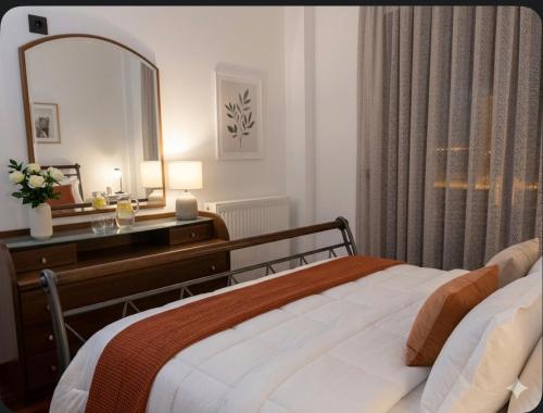 a bedroom with a bed with a dresser and a mirror at Anna's sea view apartment in Kánithos