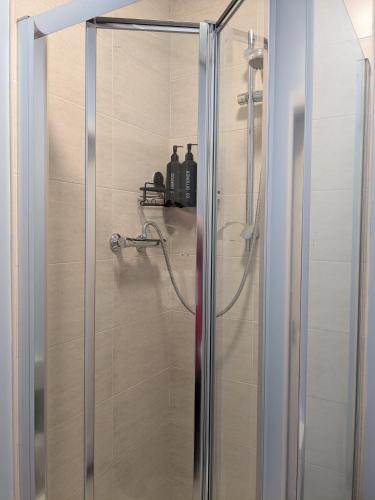 a shower with a glass door in a bathroom at The Unicorn Inn in Richmond