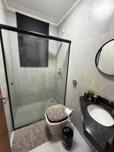 a bathroom with a shower and a toilet and a sink at Sinta-se em Casa in Cornélio Procópio