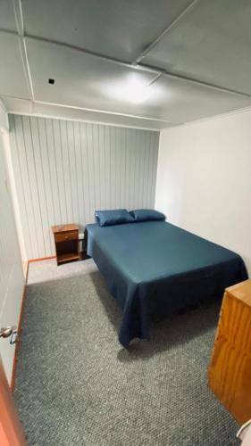 a bedroom with a blue bed in a room at Hostal Santa Sabina in Concepción