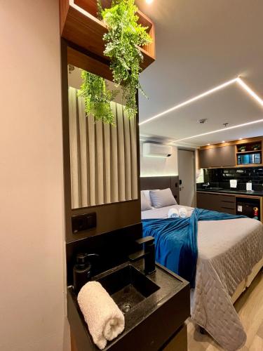 a bedroom with a bed and a sink with plants at Edition 201- Flat aconchegante no Cabo Branco - ASKA in João Pessoa