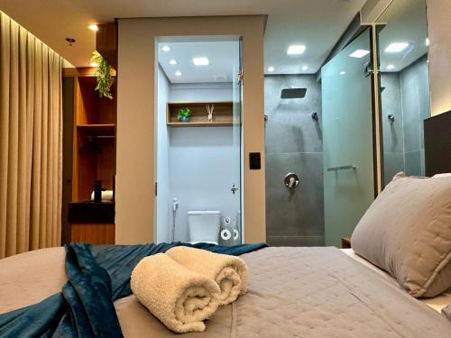 a bedroom with a shower and a bed with a towel at Edition 201- Flat aconchegante no Cabo Branco - ASKA in João Pessoa