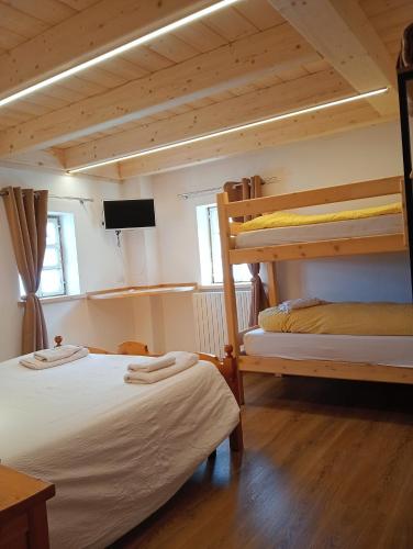 a room with two bunk beds and a flat screen tv at canton 520 appartamenti self check in in Livigno