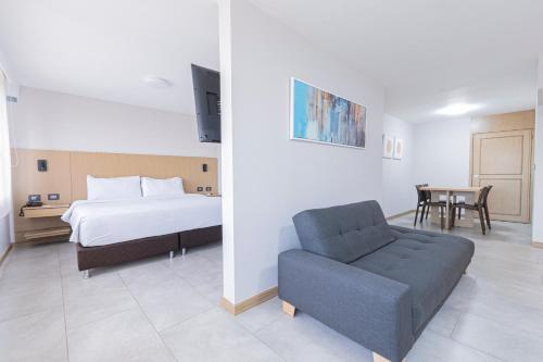 ein Schlafzimmer mit einem Bett, einem Stuhl und einem Tisch in der Unterkunft Hotel Dann Cali in Cali
