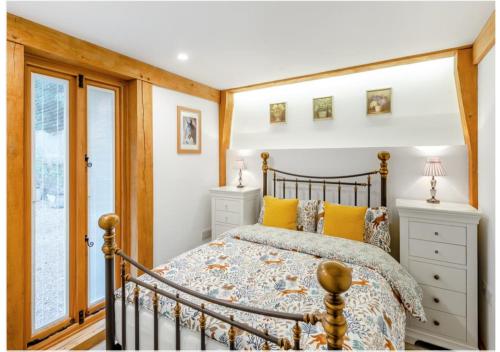 a bedroom with a bed with yellow pillows at The Saddlery Barn Retreat in Ashford
