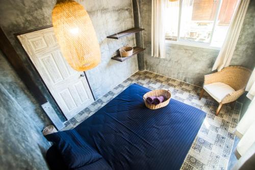 a bedroom with a blue bed with a basket on the floor at Sweet Life Community Guesthouse in Ko Lanta
