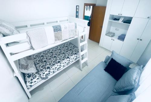 a small room with a bunk bed and a couch at Sea & Pool View Apt 1 in Aourir