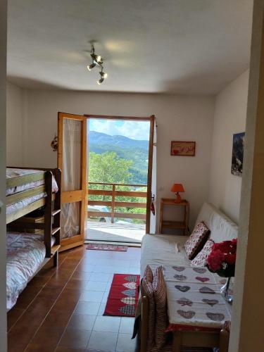 a living room with a bed and a sliding glass door at Lo Scoiattolo e il Ghiro in Fiumalbo