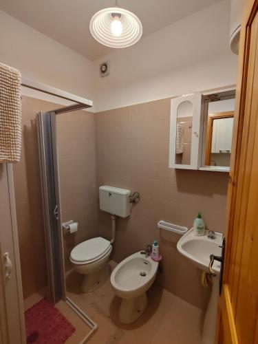 a bathroom with a toilet and a sink at Lo Scoiattolo e il Ghiro in Fiumalbo
