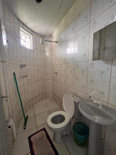 a bathroom with a toilet and a sink at Suítes FM in Cavalcante