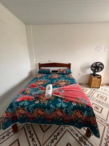 a bedroom with a bed with a colorful bedspread at Suítes FM in Cavalcante