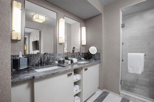 a bathroom with two sinks and a shower at Conrad Fort Lauderdale Beach in Fort Lauderdale