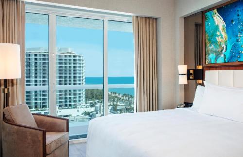 a hotel room with a bed and a large window at Conrad Fort Lauderdale Beach in Fort Lauderdale