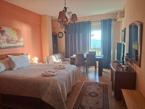 a bedroom with a bed and a table and a television at Sofia's pottery house in Volos