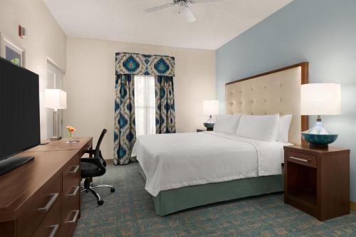 a bedroom with a bed and a desk and a television at Homewood Suites by Hilton Fort Myers in Fort Myers