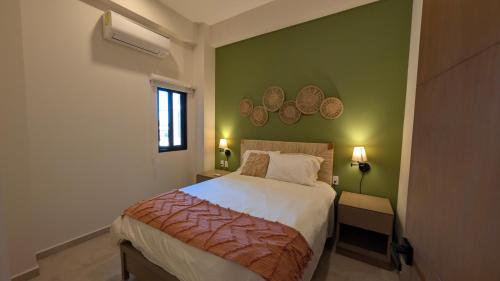 a bedroom with a bed and a green wall at Vista Cortes 2BR 2BA Condo - Walk to the Malecon! in La Paz
