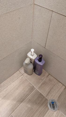 a corner of a tiled room with two containers on the floor at Vista Cortes 2BR 2BA Condo - Walk to the Malecon! in La Paz