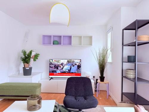 a living room with a tv on a white wall at Spacious 4-Bed Home with Workspace in Coundon