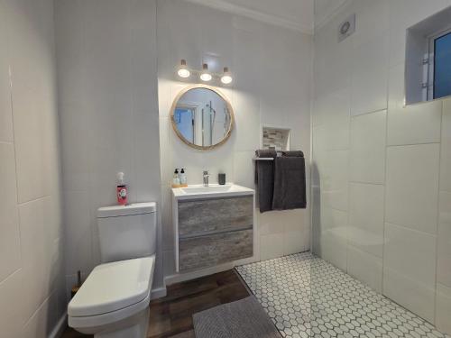 a bathroom with a toilet and a sink and a mirror at ShipsBell 5B in St Francis Bay