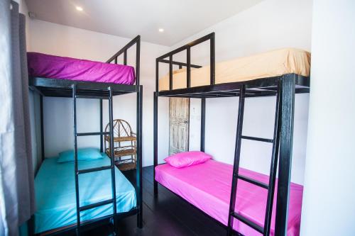 two bunk beds in a room with pink and blue at Sweet Life Guesthouse in Ko Lanta