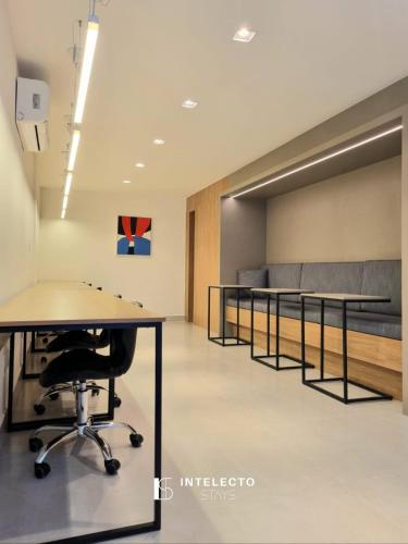 a conference room with a table and benches at GO 255 Residencial c/ Piscina, Academia e Jacuzzi in Poços de Caldas