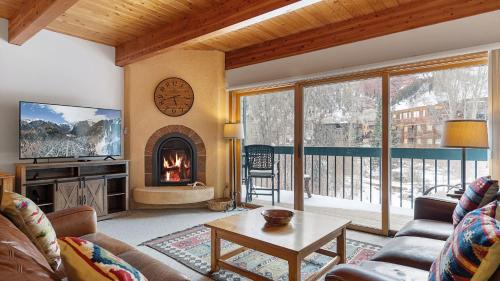 a living room with a couch and a fireplace at Riverside Condos D01 by AvantStay Condo Close To Downtown Town Park Ski Lift 8 in Telluride