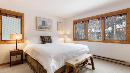 a bedroom with a bed and two windows at Riverside Condos D01 by AvantStay Condo Close To Downtown Town Park Ski Lift 8 in Telluride