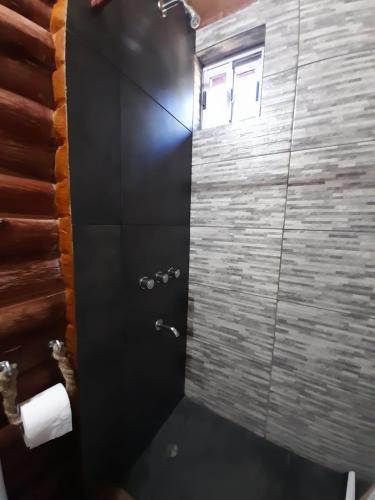 a bathroom with a shower with a black door at La Ardilla Chueca in Luján