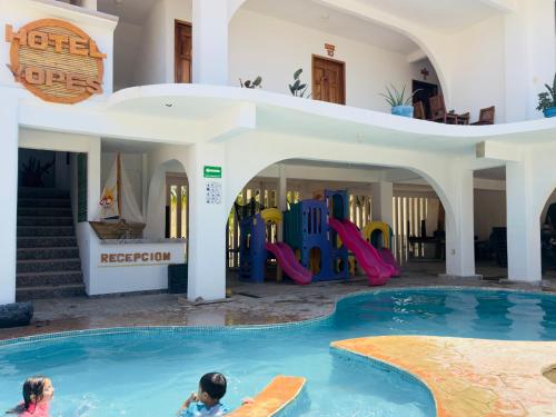 two children playing in a swimming pool in a house at Hotel Yopez in Acapulco