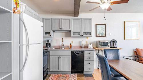 a kitchen with white cabinets and a table and a refrigerator at Columbia Place 5 by AvantStay Ski-InSki-Out Unit in Great Location in Telluride