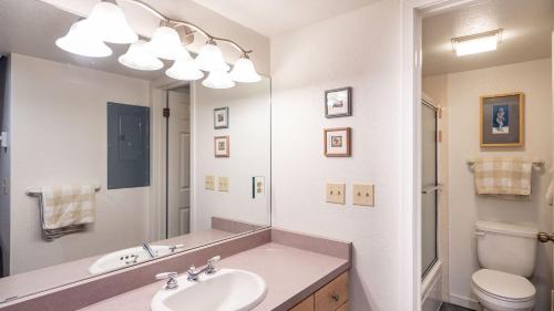 a bathroom with a sink and a toilet and a mirror at Columbia Place 5 by AvantStay Ski-InSki-Out Unit in Great Location in Telluride