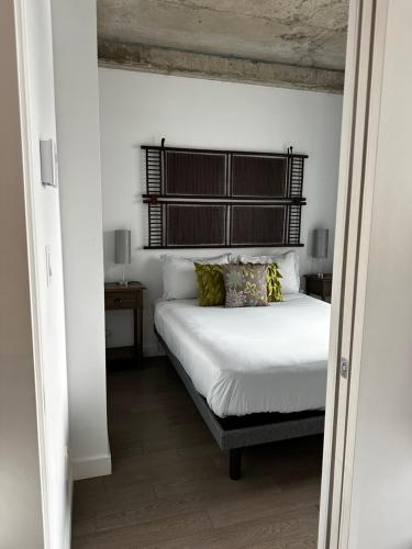 a bedroom with a bed with white sheets and pillows at Condo "Imagine" - stationnement privé inclus in Quebec City