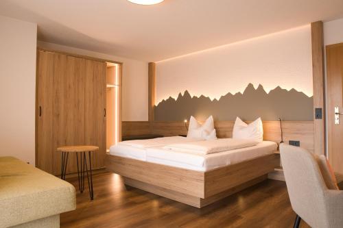 a bedroom with a bed and a table and a chair at Landhotel Schellenberg in Überlingen