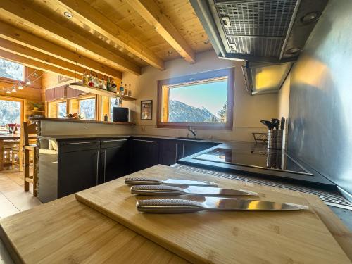 a kitchen with a wooden counter with knives on it at Chalet Boder - Vue MontBlanc - Cheminée in Finhaut