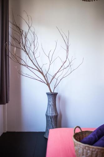 a vase with branches in it sitting on a table at Sweet Life Guesthouse in Ko Lanta