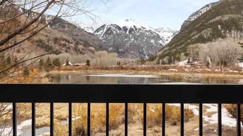 a view from a balcony of a lake and mountains at Riverside Condos B101 by AvantStay Condo Close To Downtown Town Park Ski Lift 8 in Telluride