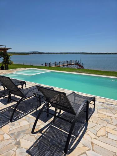 a table and chairs next to a swimming pool at Riviera Barão de Antonina - Chalés na Represa - Piscina vista incrível in Barão de Antonina
