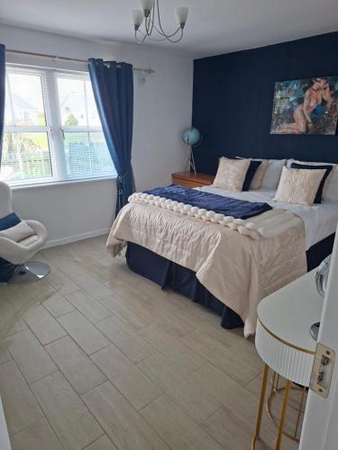 a bedroom with a bed and a blue wall at Notre Petit Chateau in Rosslare Harbour