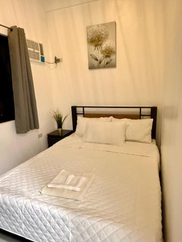 a bedroom with a bed with two towels on it at Log Cabin Tagaytay in Tagaytay