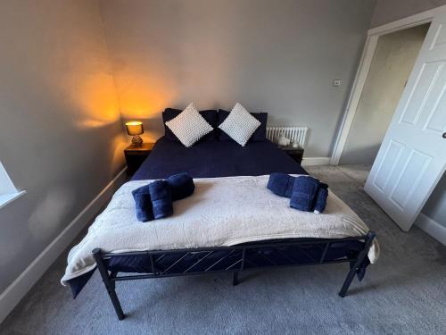 a bedroom with a large bed with blue pillows at Central Near Hospital 2 Bedroom - Sleeps 4 - Self Check In - Fully Furnished in Carlisle