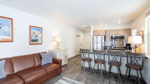 a living room with a couch and a kitchen at Etta Place 1 by AvantStay Ski In Ski Out Unit w Views of the Slopes in Telluride