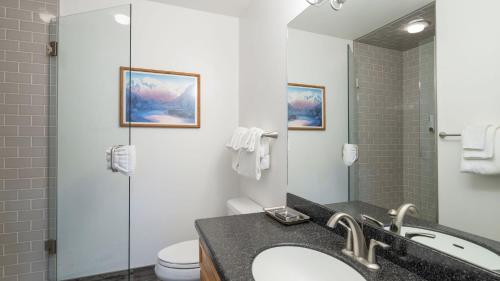 a bathroom with a sink and a toilet and a mirror at Etta Place 1 by AvantStay Ski In Ski Out Unit w Views of the Slopes in Telluride