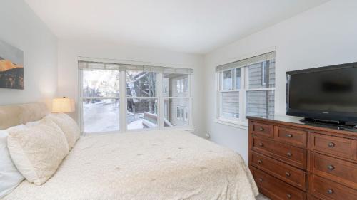 a bedroom with a bed and a flat screen tv at Etta Place 1 by AvantStay Ski In Ski Out Unit w Views of the Slopes in Telluride