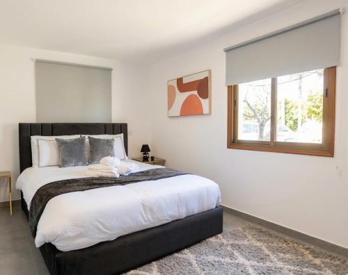 a bedroom with a large bed and a window at TelMar Kiti Escape House in Kiti