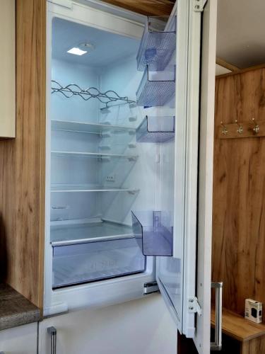 an empty refrigerator with its door open in a kitchen at Whitstable Hemsworth Villa in Seasalter