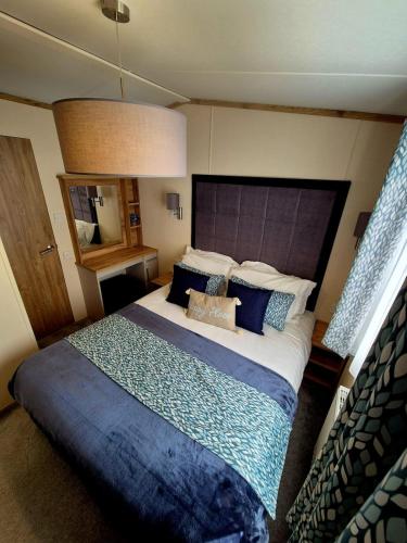 a bedroom with a large bed with blue pillows at Whitstable Hemsworth Villa in Seasalter