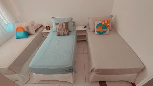 a small room with two beds in it at Pousada Macdonald in Eunápolis