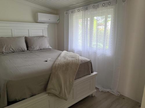 a bedroom with a bed and a window with white curtains at Heaven Can Wait APT2 in Steer Town