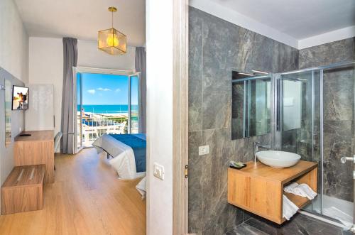 a bathroom with a sink and a shower with a view of the ocean at Hotel Rialto Suisse in Lido di Camaiore